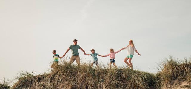 family walking on dunes at beach